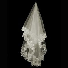 a white veil hanging from the ceiling in front of a black background with flowers on it