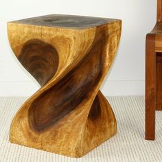 a wooden chair sitting next to a table with a wood sculpture on top of it