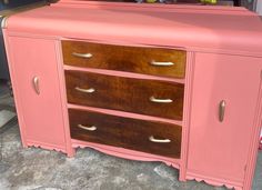 a pink dresser with gold handles and drawers