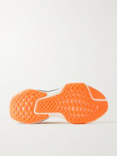 an orange tennis shoe on a white background