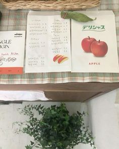 an open book sitting on top of a table next to a basket filled with fruit