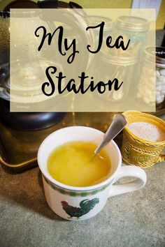 a cup of tea sitting on top of a counter next to a pot and saucer