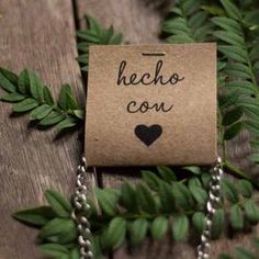 a piece of paper with the words hecho con on it hanging from a chain