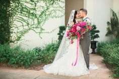 a bride and groom standing in front of a building