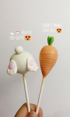 a hand holding two carrot lollipops with stickers on them that say don't mind, but this veggie is cute