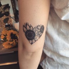 a woman's arm with a sunflower tattoo on the left side of her arm