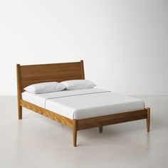 a bed with white pillows and wooden headboard