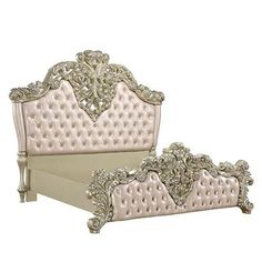 a white bed with an ornate headboard and foot board