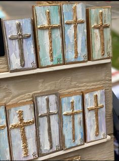 the shelves are decorated with wooden crosses and painted in pastel blue, white and gold