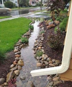 a stream running through a yard next to a house