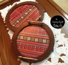 two wooden trays sitting on top of a doily covered table with decorative designs