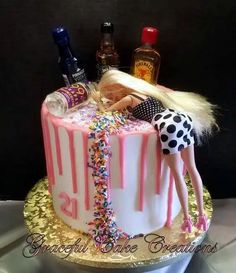 a birthday cake with a barbie doll on top and confetti sprinkles