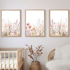 three floral paintings hang on the wall above a crib