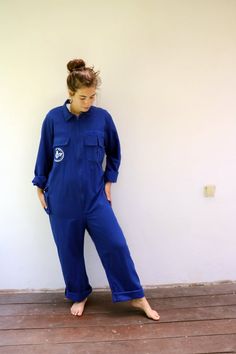 Vintage blue chore coveralls from Israeli flight school printed in Hebrew on the back and front..." Amal Ramat David Building the future"  with an F16 airplane drawing on the back panel, pockets with velcro opening, zips down the front, elastic waist on the back, soft cotton.  an oversize and loose fit can be worn by both men and women. aside from minor signs of wear...The back hem of the pants is worn, otherwise, good vintage condition clean ready to wear. **Model is 5'8" and a size s/m for ref Blue Utility Jumpsuits And Rompers With Relaxed Fit, Blue Relaxed Fit Utility Jumpsuit Or Romper, Blue Utility Jumpsuit With Relaxed Fit, Blue Relaxed Fit Utility Jumpsuits And Rompers, Blue Utility Jumpsuits And Rompers For Work, Blue Cotton Jumpsuits And Rompers, Blue Overalls With Pockets, Blue Workwear Overalls, Long Sleeve Cotton Denim Utility Jumpsuit