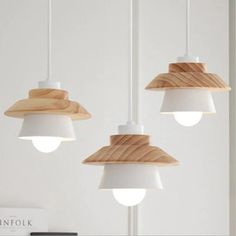 three wooden lamps hanging from a ceiling