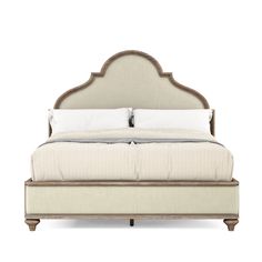 an upholstered bed with white sheets and pillows