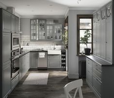 a large kitchen with stainless steel appliances and wood flooring