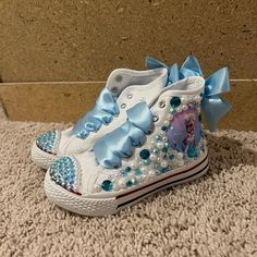 Custom Look A Like Converse, Kids Elsa Shoes ! Have Diamonds And Pearls Around It With Satin Lace Bow ! Condition: New Brand: Zebra Acydy / Custom Made Size: 11 / 17 Cm Message Me With Any Questions:) Cute Blue Sneakers For School, Blue Round Toe Sneakers For School, Cute Blue Non-slip Sneakers, Light Blue Sneakers For School, Light Blue Round Toe Sneakers For School, Cute Blue Slip-on Sneakers, Elsa Shoes, Bling Baby Shoes, Frozen Shoes