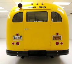 the back end of a yellow bus with license plates