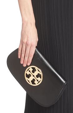 A gleaming logo medallion stands out on the rich leather exterior of a compact clutch fitted with an optional chain strap for hands-free wear. Structured silhouette with flat base for stability Lined Leather Imported Chic Evening Clutch With Gold-tone Logo Plaque, Chic Formal Clutch With Gold-tone Logo Plaque, Formal Compact Leather Clutch, Tory Burch Clutch, Purse Collection, Leather Clutch, Clutch Purse, Hands Free, Chain Strap