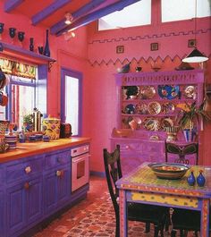 a kitchen with pink walls and purple cabinets