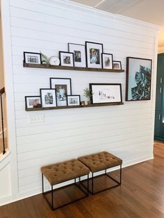 two benches are in front of the wall with pictures on it and frames above them