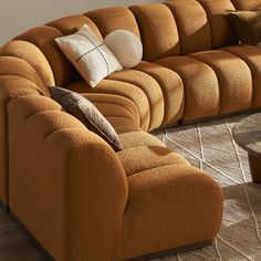 a large orange couch sitting on top of a wooden floor next to a coffee table