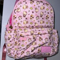 a pink hello kitty backpack hanging on the wall