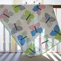 a quilted blanket sitting on top of a wooden rail next to a window sill