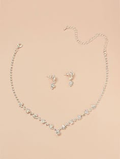 a necklace and earring set on a pink background