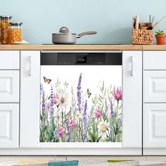 a kitchen with flowers and butterflies painted on the side of the oven door, next to a potted plant