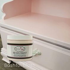 a close up of a white dresser with a pink paint on the top and bottom