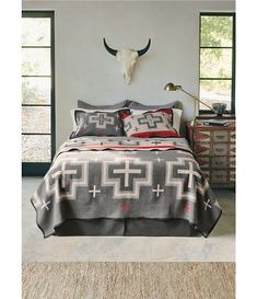 a bed with a cow skull mounted on the wall above it and two pillows in front of it