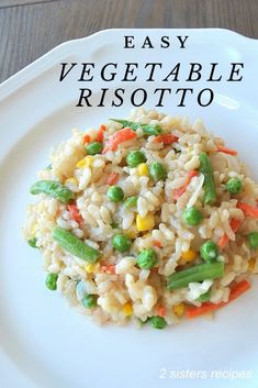 a white plate topped with rice and veggies on top of a wooden table