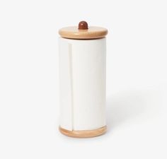 a white canister with a wooden lid