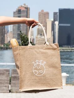 a person holding a bag with food in it near the water and city skylines