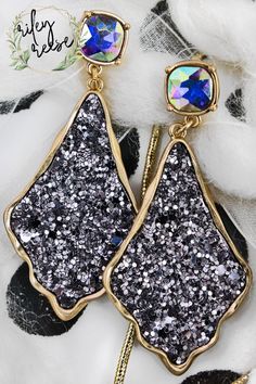 Add glitz and glam with these glittering earrings! Glitter Covered Faux Leather Metal Trim and Backing with Cut-Out Design Worn Goldtone Large Iridescent Square Gemstone Like Crystals Wavy Moroccan Inspired Teardrop Shape 2.75" Post Style Earrings Lead & Nickel Compliance Glitter Earrings, Metal Trim, Glitz And Glam, Cut Out Design, Style Earrings, Druzy Ring, Cut Out, Gold Tones, Faux Leather