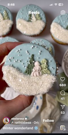 someone is holding up some frosted cupcakes that are decorated with icing