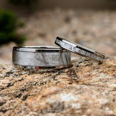 two wedding bands sitting on top of a rock