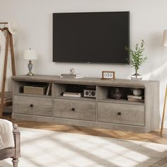 a large flat screen tv mounted to the side of a wooden entertainment center in a living room