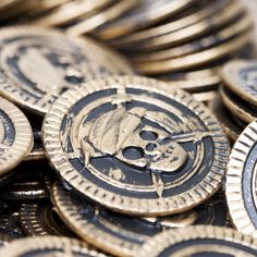 a pile of gold coins with skulls and bones painted on the front, sitting next to each other