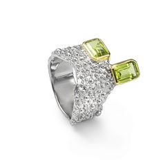 This ring from German Kabirski's Buds and Beans Collection challenges conventional design with its unique setting of two octagon-cut Peridot gemstones. One stone is set vertically, the other horizontally, embodying a design perfect for those who appreciate seeing things from multiple perspectives and find harmony in contrasts. The dual plating of White Rhodium and 18K Gold enhances the design's complexity, while the band's organic-like texture—a signature of Kabirski's work—adds an earthy, tacti Luxury Multi-stone Peridot Ring, Luxury Peridot Multi-stone Rings, Luxury Peridot Rings With Accent Stones, Elegant Octagon Multi-stone Ring, Fine Jewelry Peridot Gemstones For Formal Occasions, Luxury Peridot Jewelry For Formal Occasions, Luxury Peridot Jewelry With Accent Stones, Formal Multi-stone Octagon Rings, Formal Octagon Multi-stone Rings