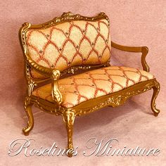 an ornately decorated chair with gold trimmings on the arm and back, against a pink background