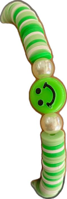 a green and white striped object with a smiley face on it's back end