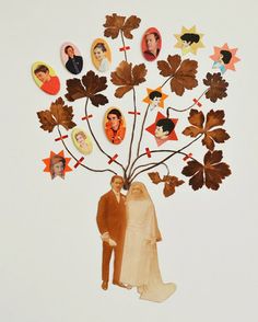 a couple standing under a tree made out of paper and cutout leaves with photos on it