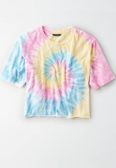 a tie - dyed t - shirt is hanging on a hanger against a white wall