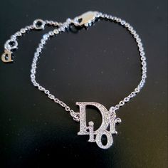 Never Worn, In Perfect Condition Vintage Authentic Christian Dior Logo Rhinestone Bracelet Made From Plated Silver Tone Metal Chain Featuring A Signature "Dior" Logo Jewelled With Swarovski Crystals And Finished With A Lobster Closure. Luxury White Gold Bracelets With Rhinestones, Luxury White Gold Bracelet With Rhinestones, Luxury Bracelets With Sparkling Stones, Designer Bracelets With Diamond Accents, Designer Silver Diamond Bracelet, Designer Silver Diamond Bracelet With Accents, Luxury Rhinestone Bracelets For Anniversary, Luxury Diamond Bracelet With Rhinestones For Party, Designer White Gold Diamond Bracelet As Gift