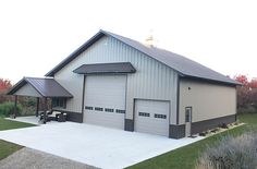 two garages are shown in the middle of a grassy area with trees and shrubs