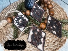 three wooden ornaments sitting on top of a table next to some nuts and pine cones