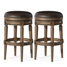 two wooden stools with leather upholstered seats on each side, one in the middle